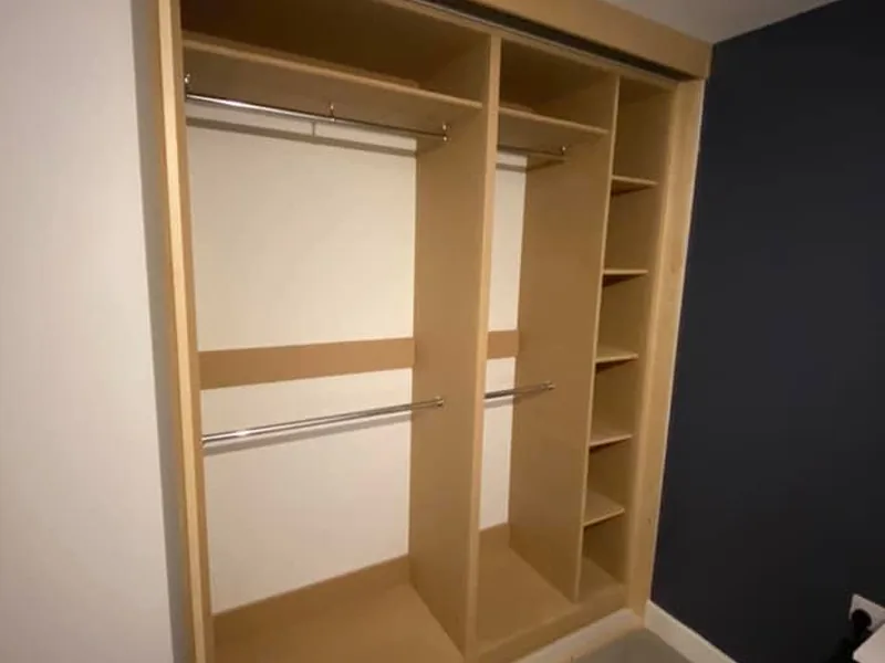 Inside a fitted wardrobe with hanging rails and shelving made to the room
