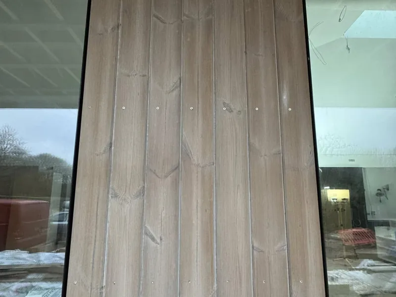 Timber cladding boards being fixed over a ventilated batten cavity