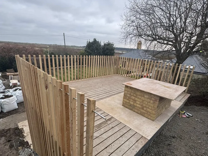 Timber slatted screen fence around a new deck with a brick built barbecue