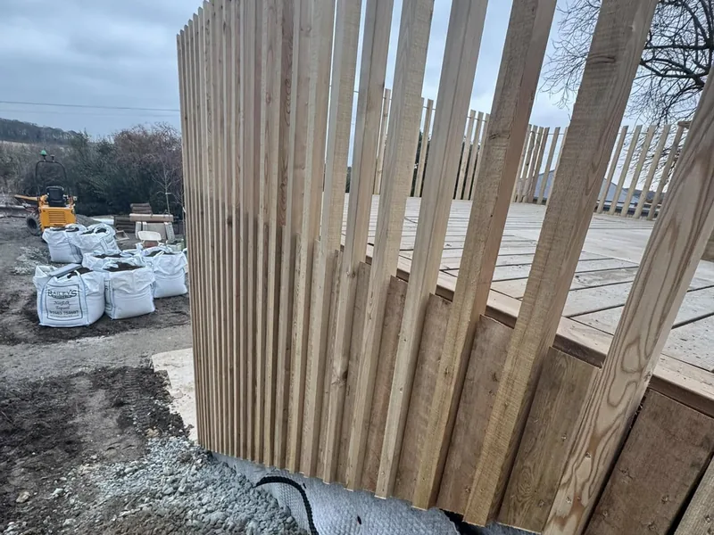 Close up of a tall vertical timber slatted screen on a construction site