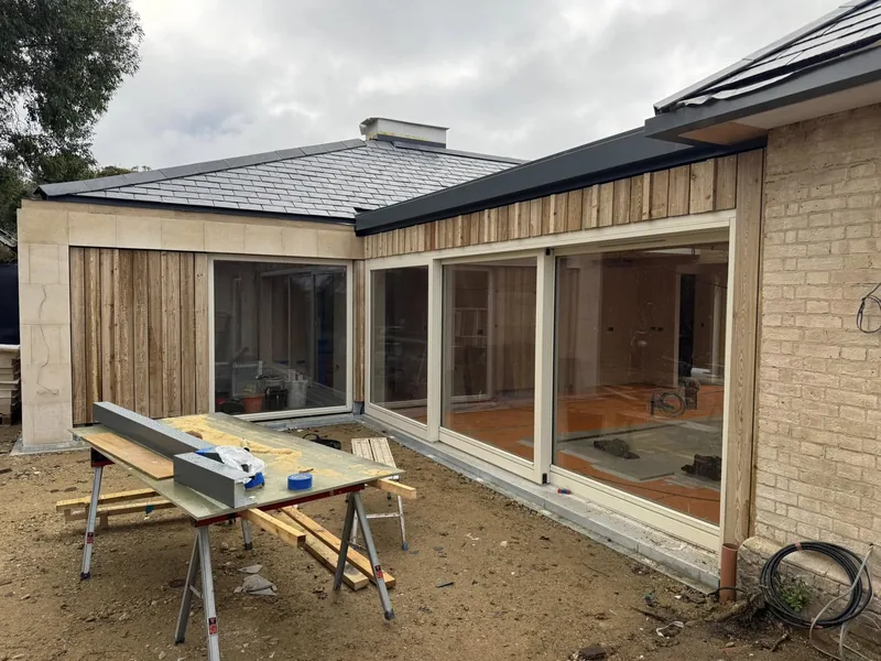 Timber cladding being installed around new windows on a single storey extension