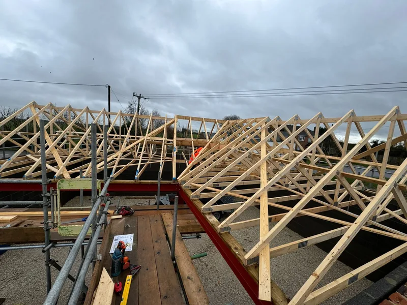 Timber trussed roof erected over a building with scaffolding around the perimeter
