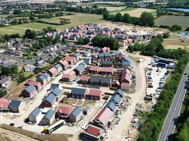 Aerial view of a new housing development with completed homes and plots still in build