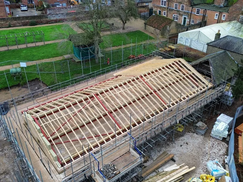 Aerial view of new timber rafters and steelwork forming a long roof over a building