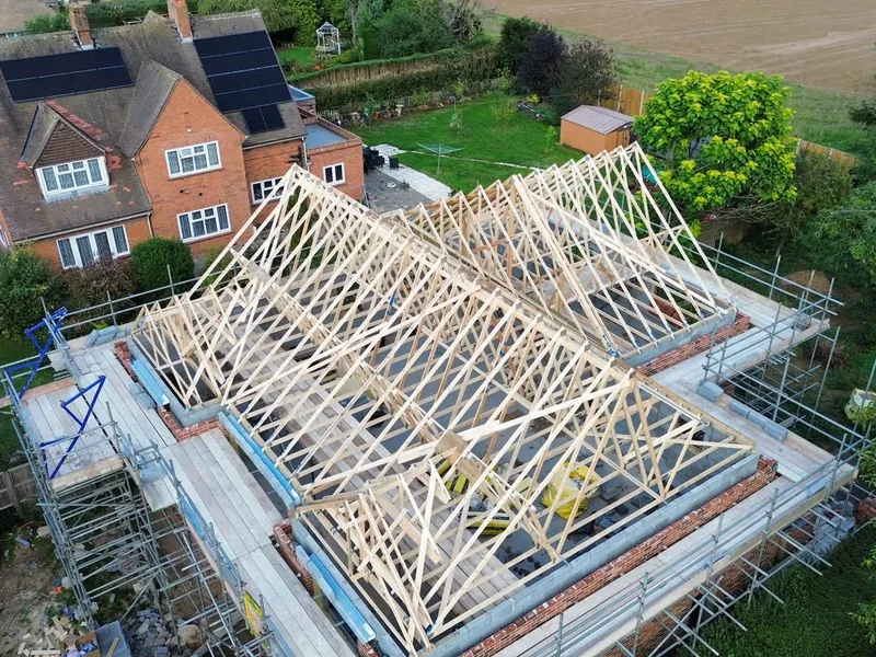 Trussed roof and valleys on the Boston house from above, with the neighbouring house and fields behind