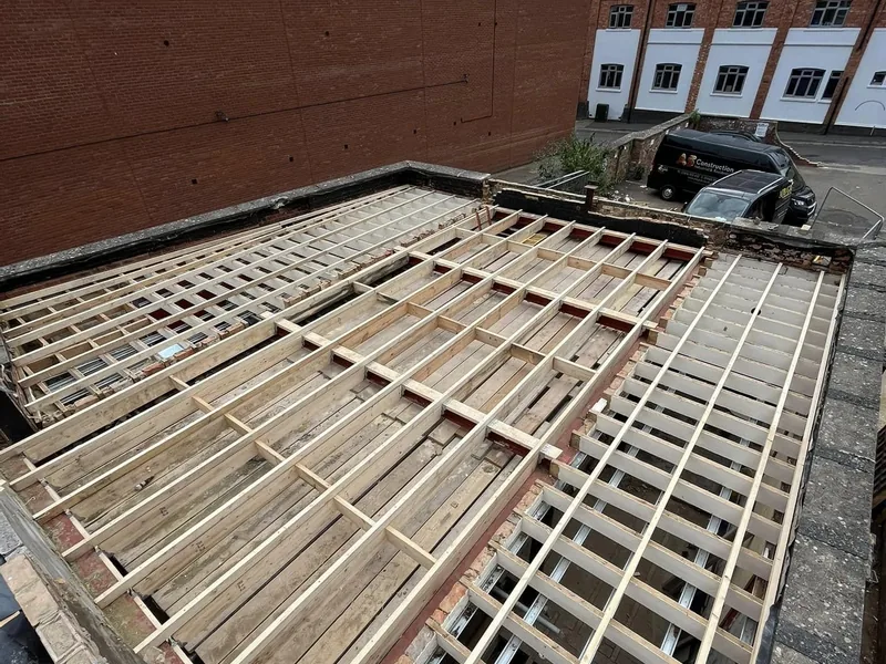 New timber flat roof joists and firrings installed over a town centre unit