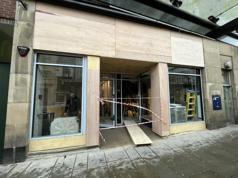 New shopfront with glazing and stone panels being fitted to a high street unit