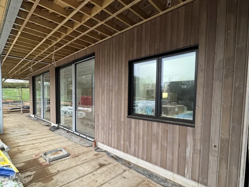 Larch cladding around windows and sliding doors on the Cromer coastal build