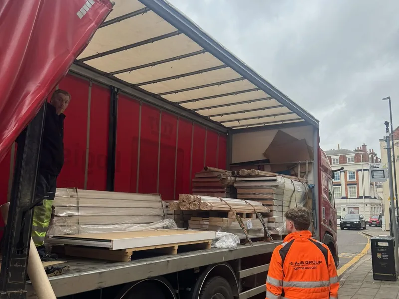Timber and board packs being unloaded from a curtain sided lorry by AJB Group workers