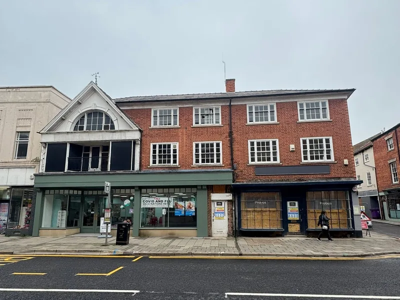 Street elevation of a three storey brick building with shopfronts at ground floor