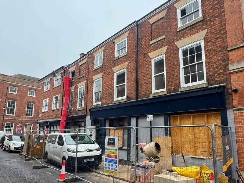 Site set up outside the conversion with a debris chute, fencing and a van on the street