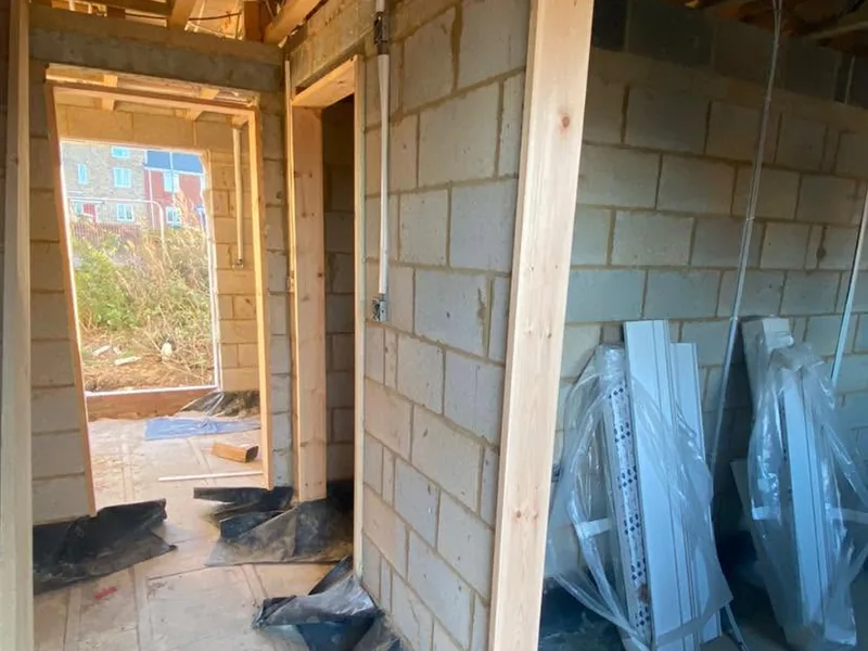 Blockwork rooms with new timber door linings and stacked materials in a new build
