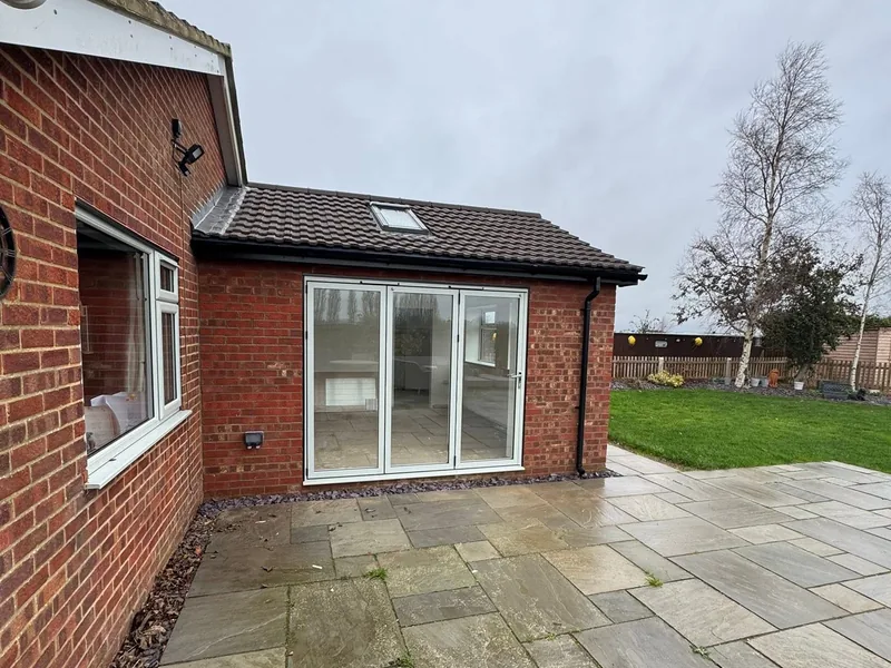 Brick extension with sliding patio doors, a rooflight and a paved patio