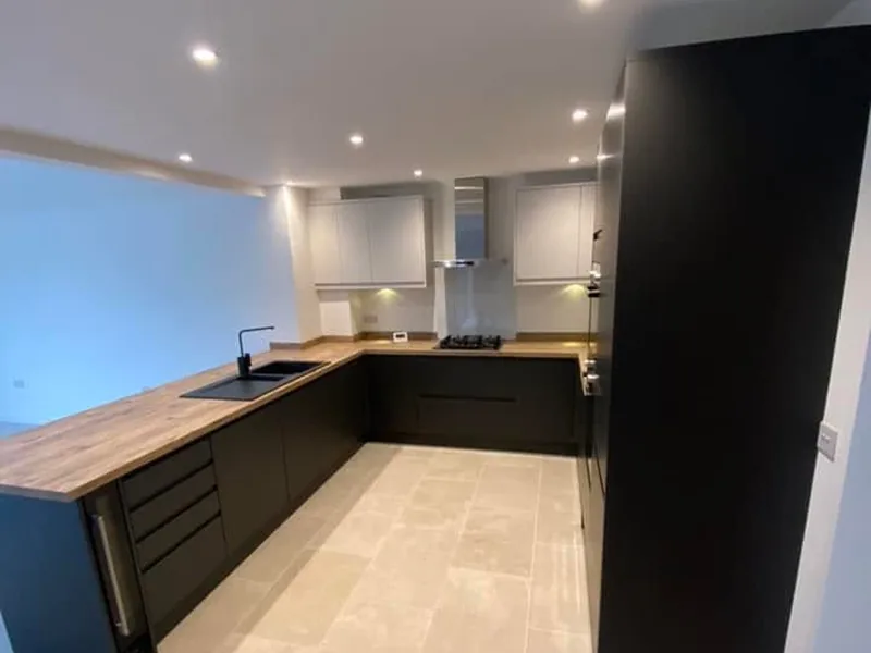 Fitted kitchen with dark grey units, timber effect worktop and integrated hob