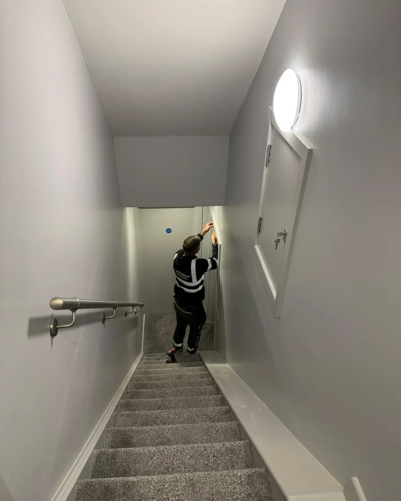 AJB Group carpenter fitting a door lining on the staircase at Four Winds, Ramsey