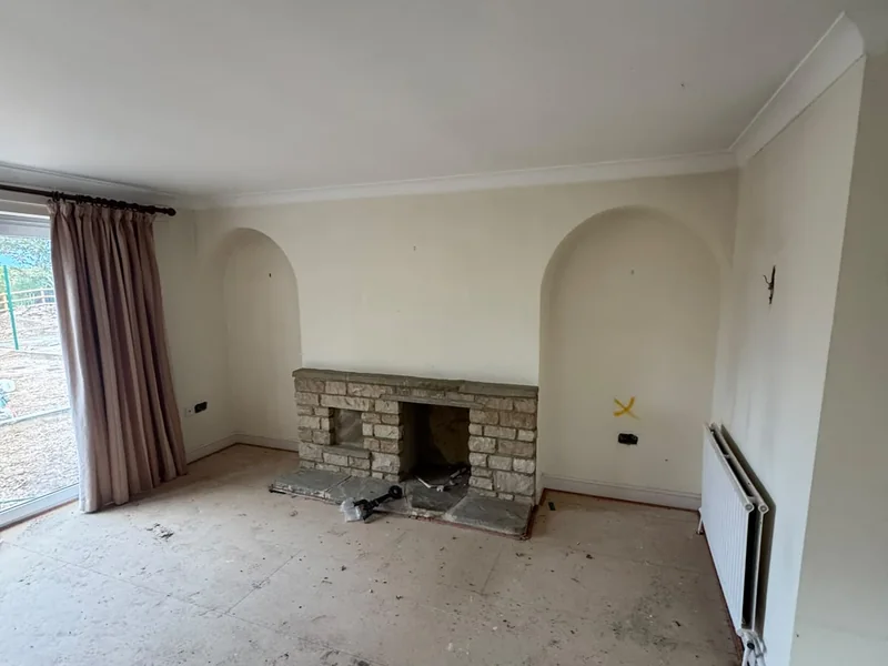 Original lounge of the Ramsey bungalow before conversion, carpet lifted and fireplace exposed