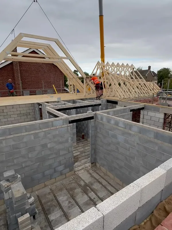An attic truss being craned onto the blockwork shell in Rippingale