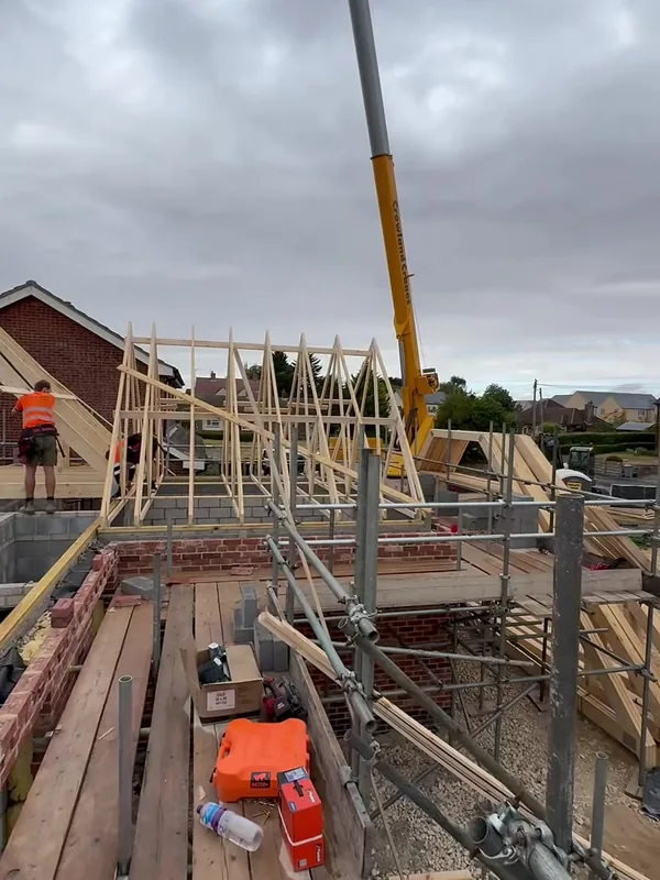 Crane on site in Rippingale with attic trusses stacked on the scaffold