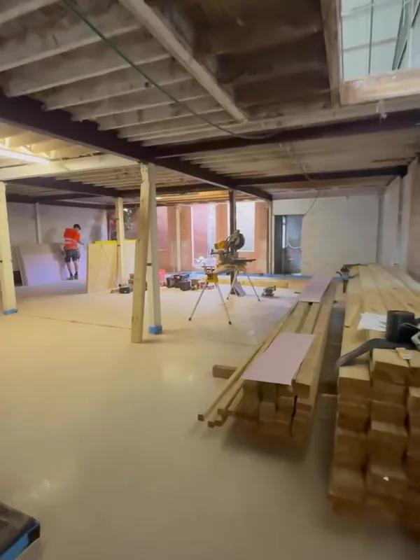 The stripped ground floor of the Stamford warehouse, with steel beams, columns and timber stacked for the new walls