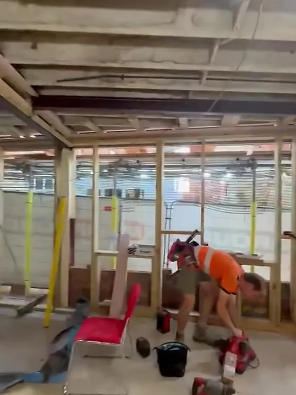 A carpenter cutting timber for the office partitions inside the Stamford warehouse