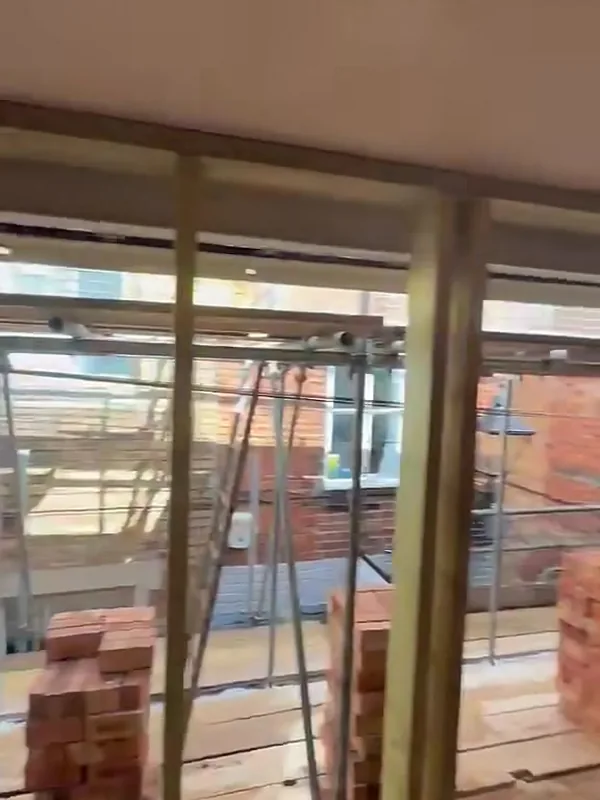 New 6x2 external timber walls on the first floor of the Stamford conversion, with bricks stacked for the new front