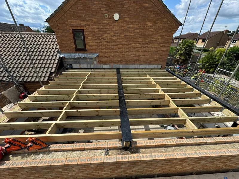 New timber joist set over a single storey extension against a brick house