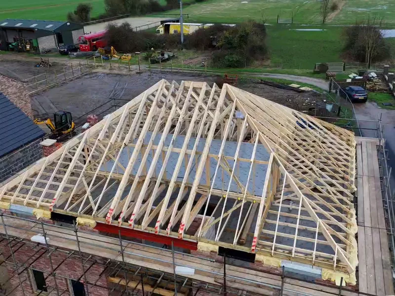 Aerial view of an attic trussed hip roof fitted by AJB Group, hip end and girder trusses in place
