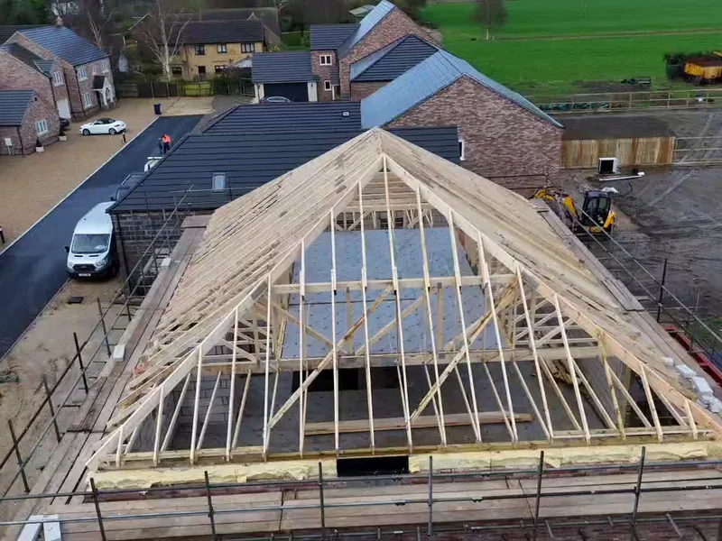Attic trussed hip roof from above showing the boarded room in roof floor deck between the truss sets