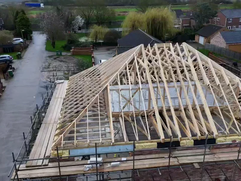 Attic truss set fixed at centres along the ridge with the hip end formed at the near gable