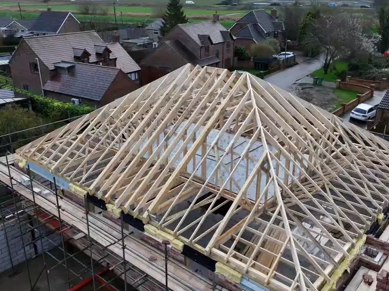 Completed attic trussed hip roof ready for felt and batten, insulation packed at the wall plate