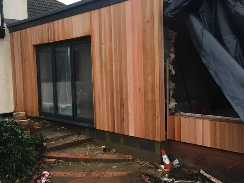 Cedar clad extension with black framed windows on a domestic property