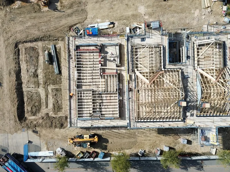 Top down aerial view of a new build under construction with timber floor structure and groundworks