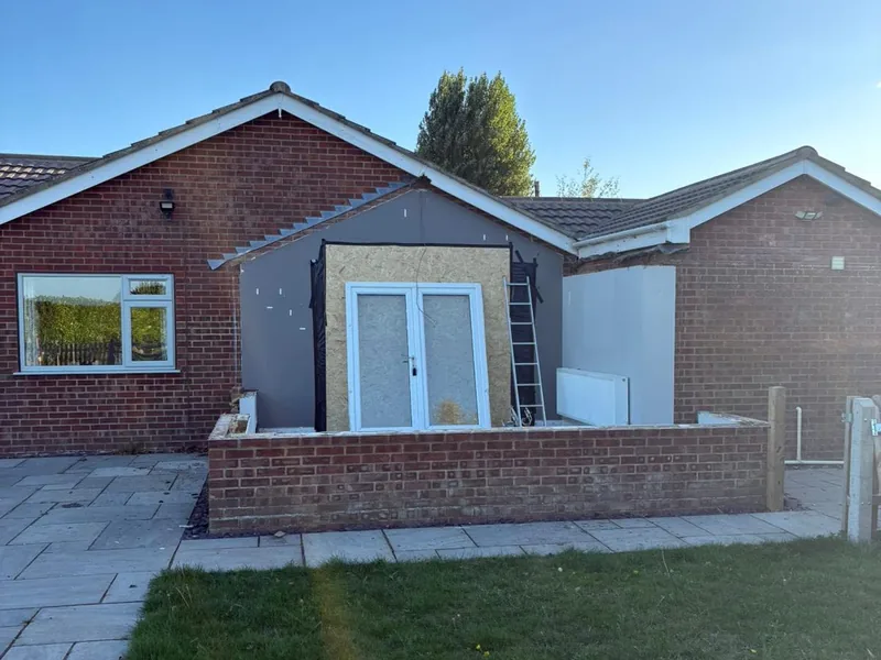 Rendered single storey extension on a brick bungalow with new white French doors