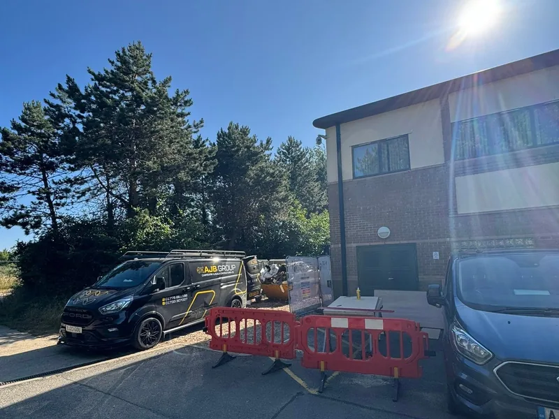 AJB Group van and red safety barriers outside a commercial building