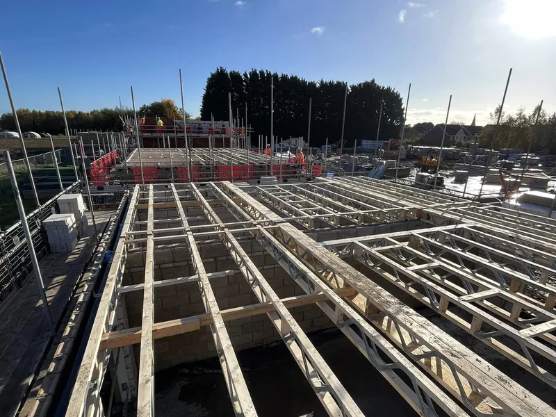 Metal web posi joists installed to form a first floor over blockwork walls on a housing site