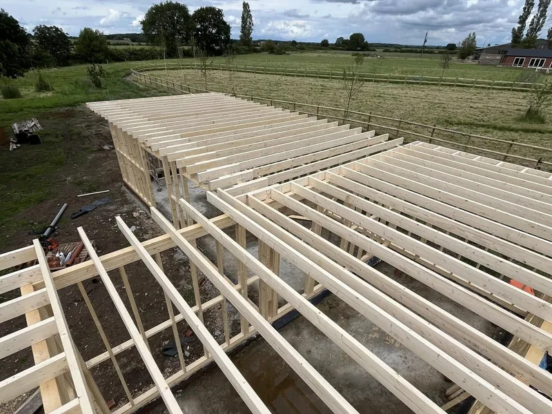Timber joists spanning the stud framed walls of a single storey building in open countryside
