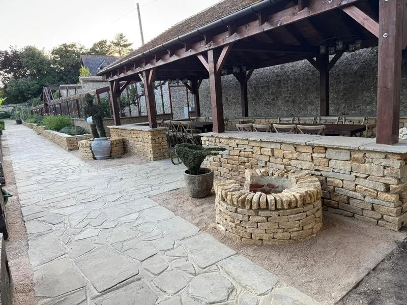 Oak framed garden pavilion with stone walls and a paved terrace
