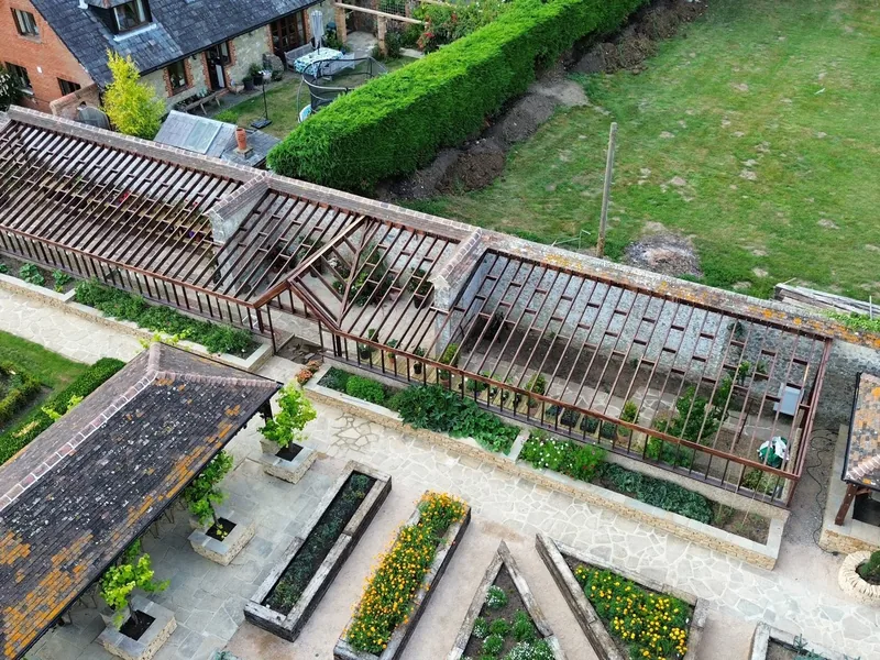 Bespoke greenhouse and timber loggia built by AJB Group in a walled kitchen garden