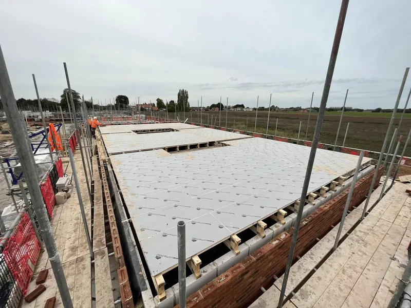 Insulation boards laid over a beam and block ground floor inside new brickwork walls