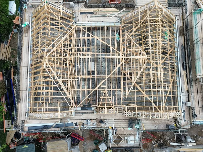 Overhead view of a cut roof structure with hips and valleys framed out over a building