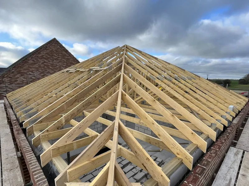 Hand cut hip roof with hip and jack rafters set out over blockwork walls