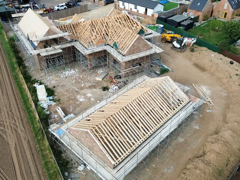 Aerial view of two new build roof structures framed out with scaffolding around them