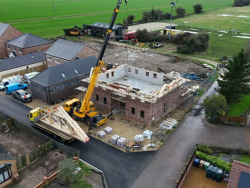Roof structure being fitted above a completed joist floor