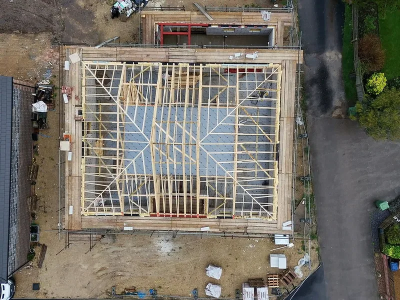 Overhead drone view of an open timber roof structure on a new house, no felt or tiles yet