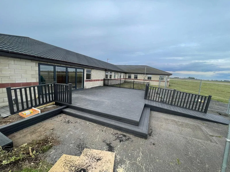 Composite decked terrace with dark balustrade outside a single storey building