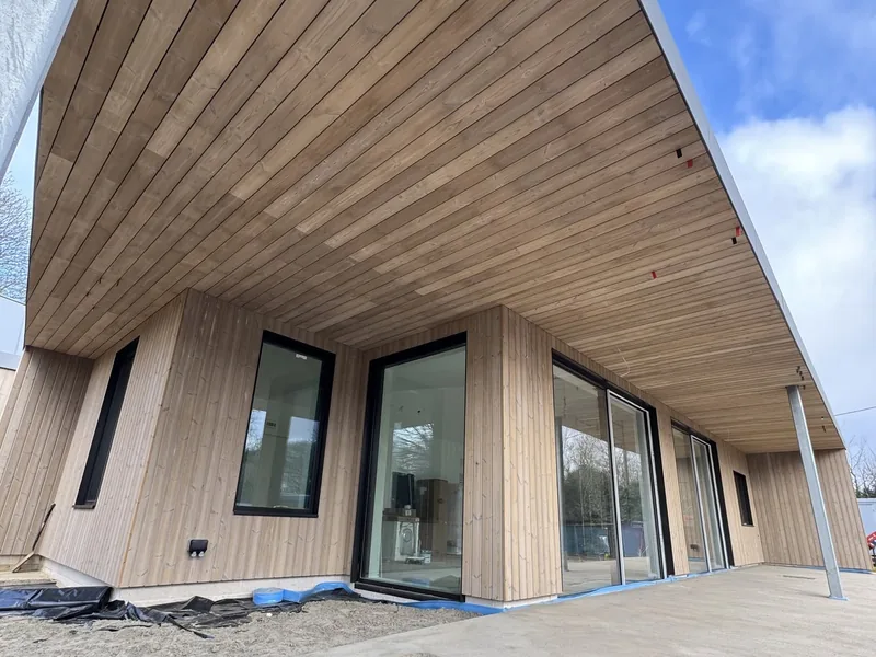 Timber clad commercial building with a clad soffit and full height glazed shopfront