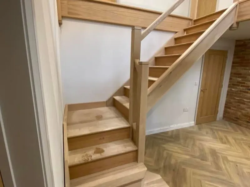 Oak staircase finished above a herringbone parquet floor