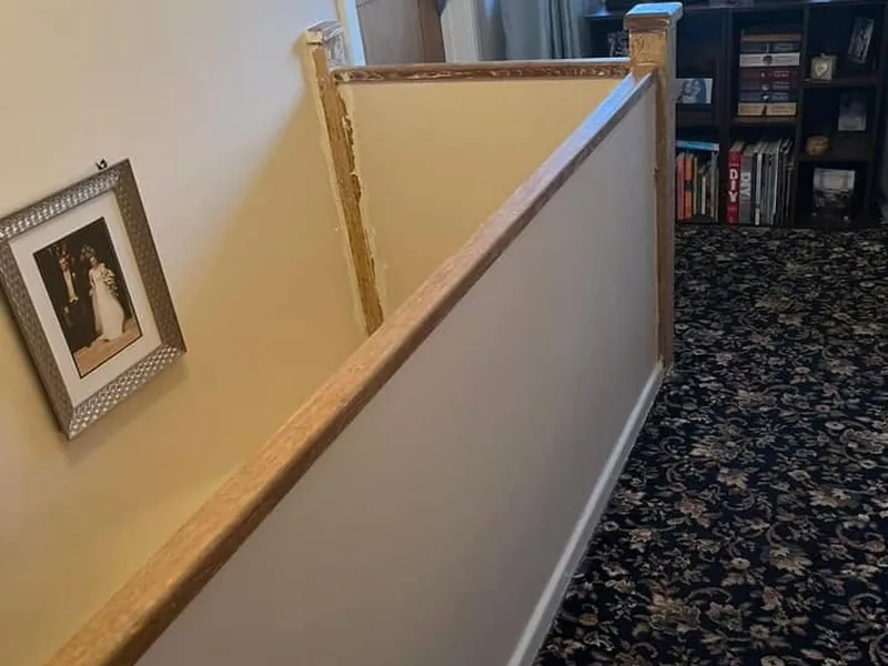 Stair balustrade being boxed in with new panelling and a timber newel post in an occupied home